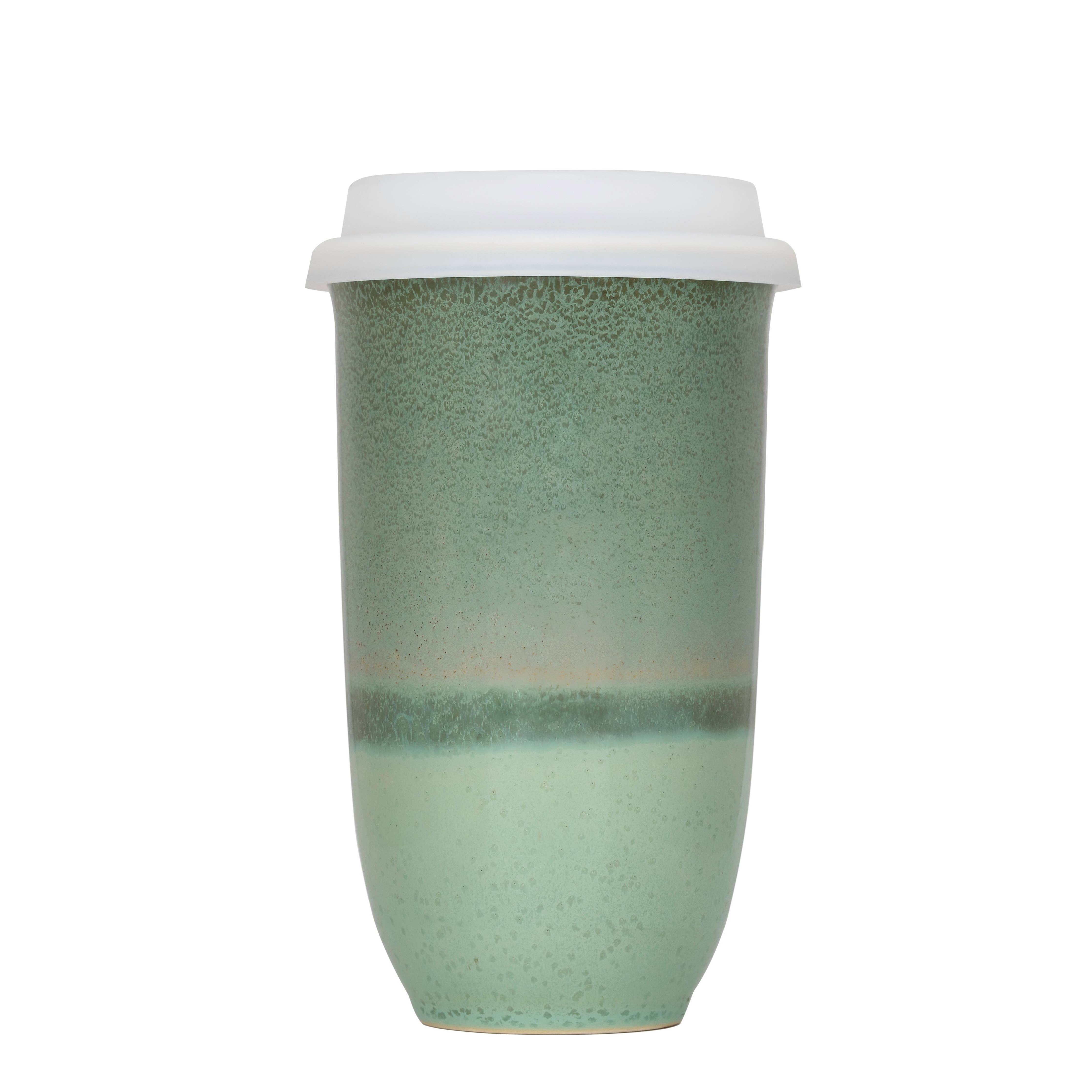 Green ceramic cup with a white lid on a white background