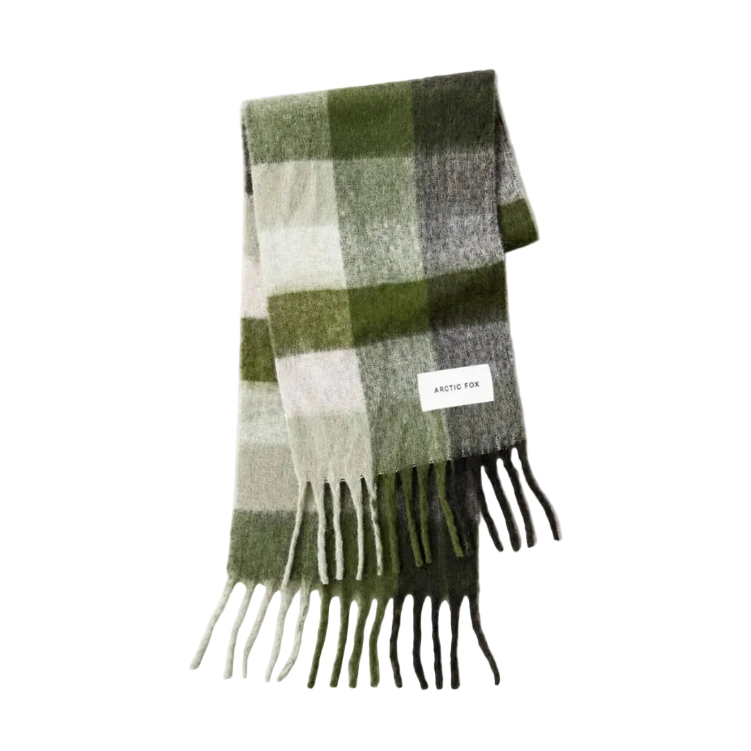A folded plaid scarf in shades of green, gray, and off-white, featuring fringe on the ends and a small white brand label that reads 'ARTIC FOX'.