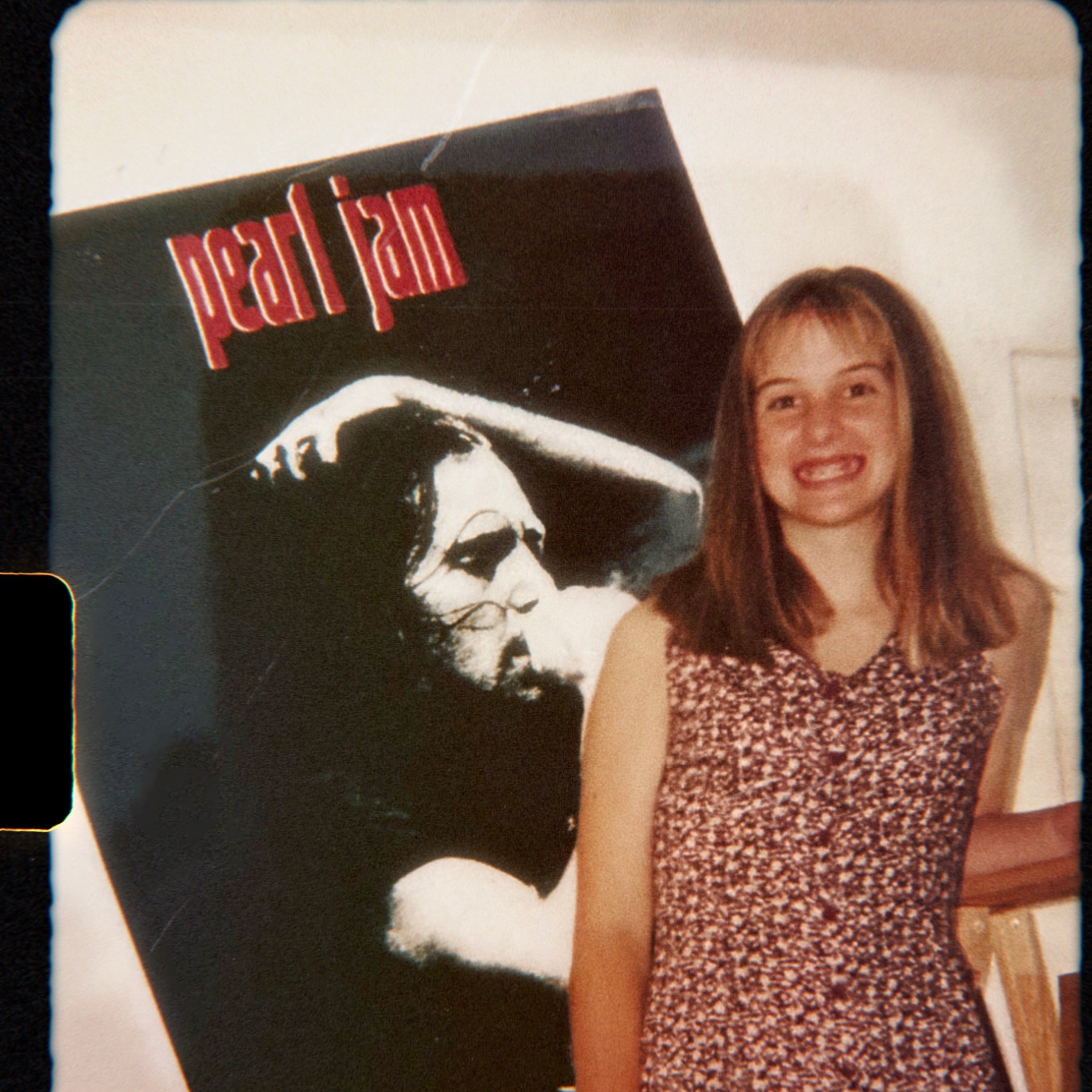 Owner, Brooke standing next to a Pearl Jam album cover