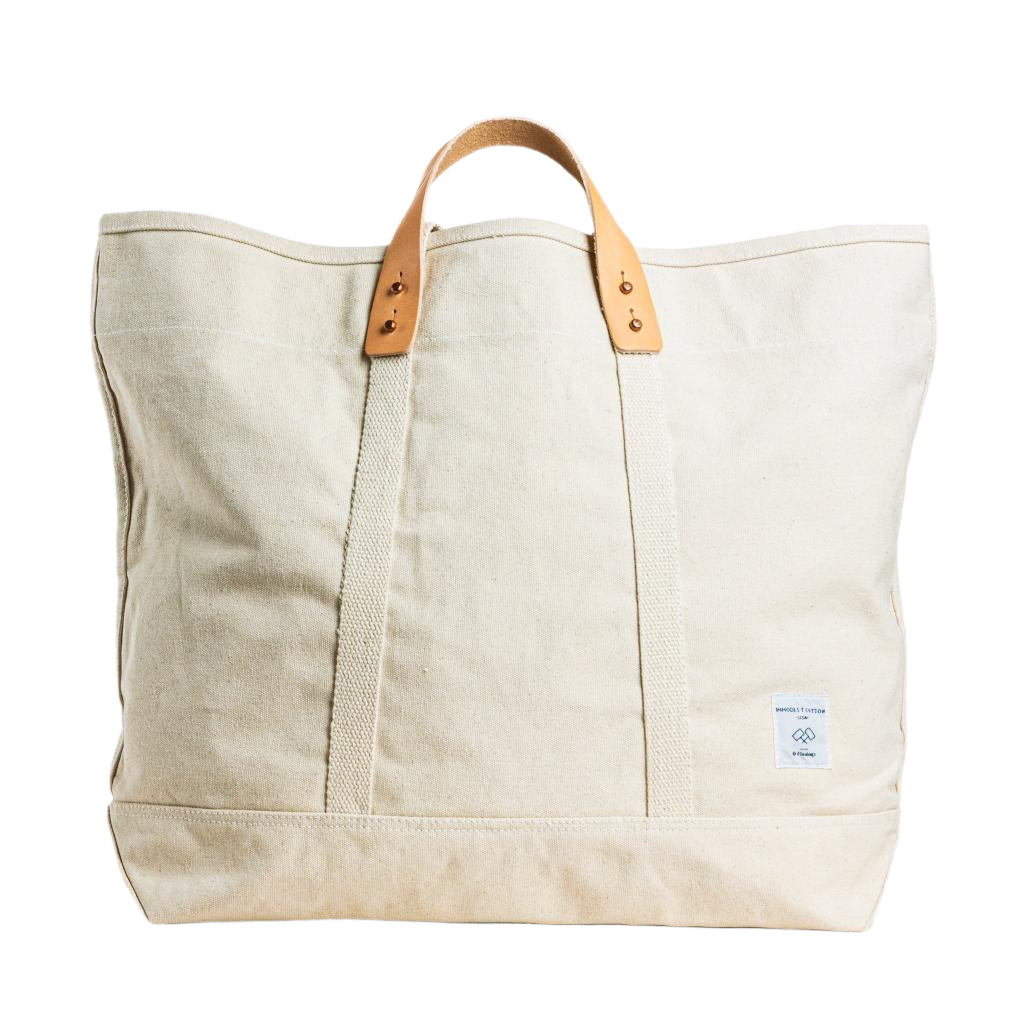 Large tote bag in natural cream canvas with sturdy handles, spacious design for travel or everyday use.