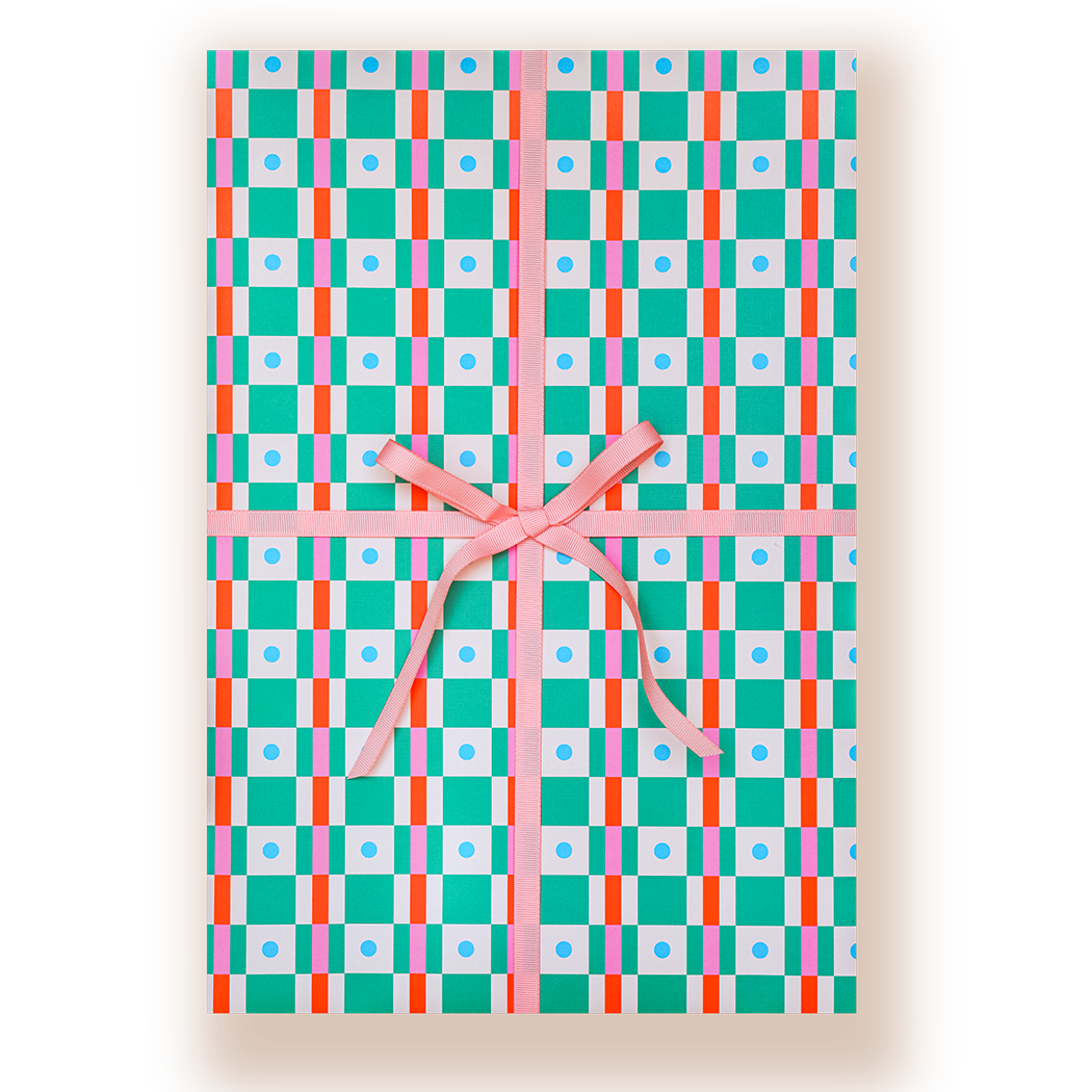 A rectangular gift box wrapped in a colorful geometric patterned paper with a pink ribbon tied in a bow at the center, shown on a white background.