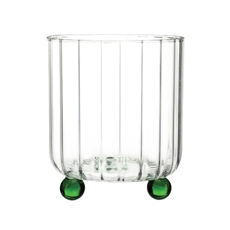 Clear ribbed glass tumbler with green glass feet, shown on a plain white background.