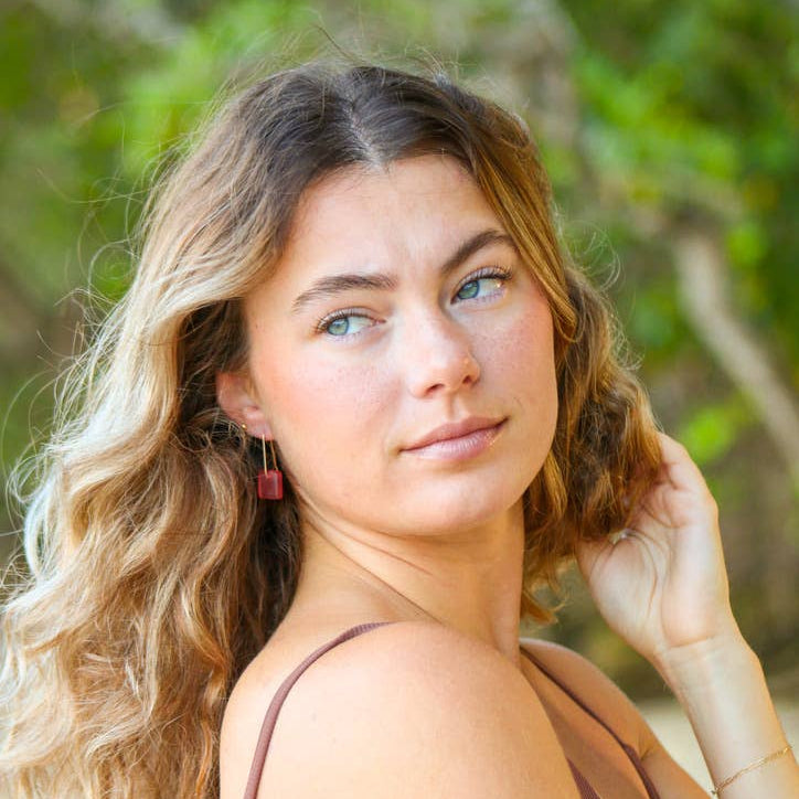 Woman with wavy hair and a brown top outdoors