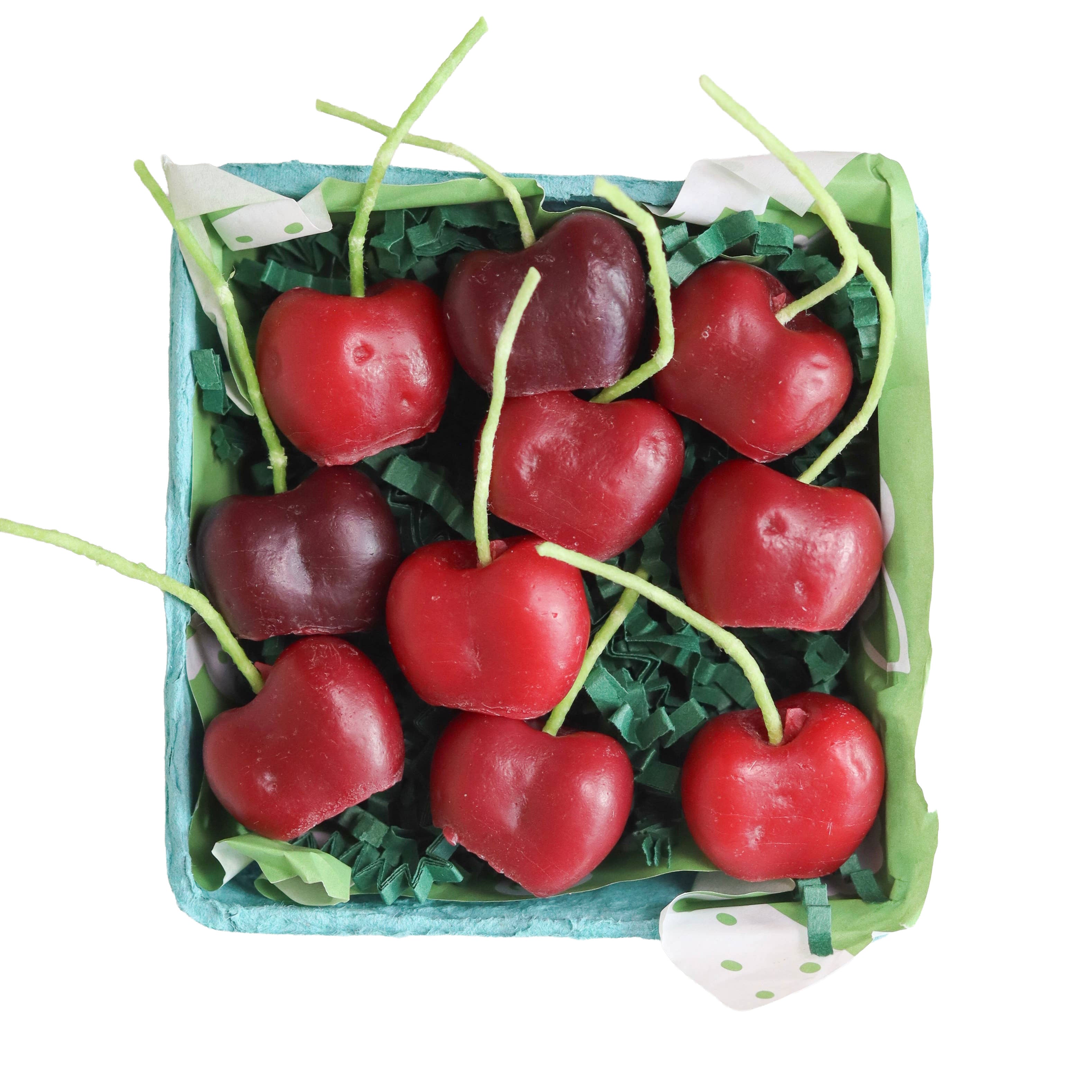 Box of red cherries with green stems on a white background
