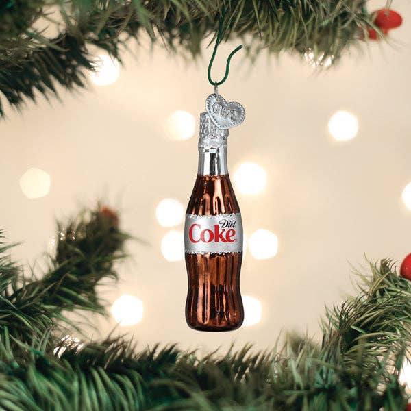 Diet Coke bottle Christmas ornament hanging on a tree with lights in the background