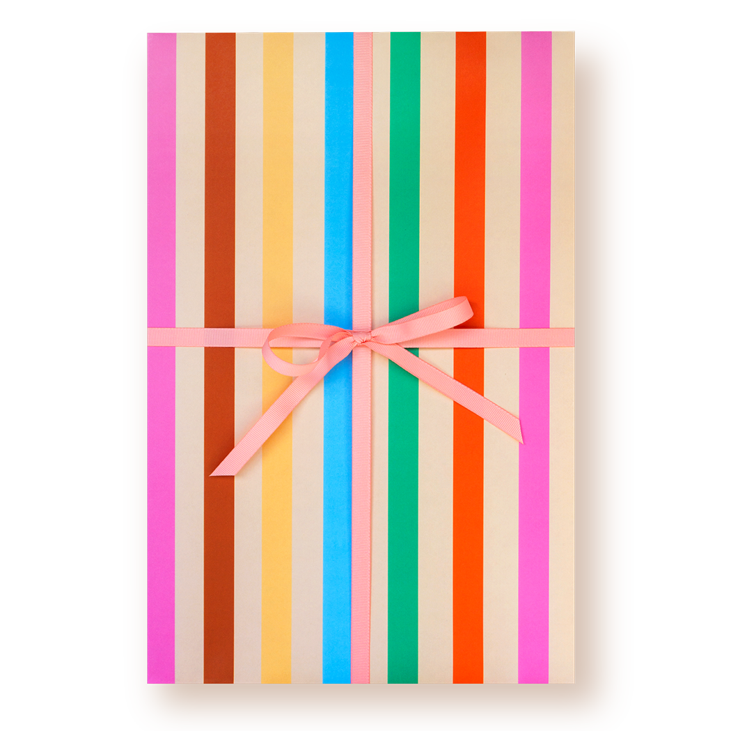 Gift box with colorful striped pattern wrapping paper and pink ribbon on a white background