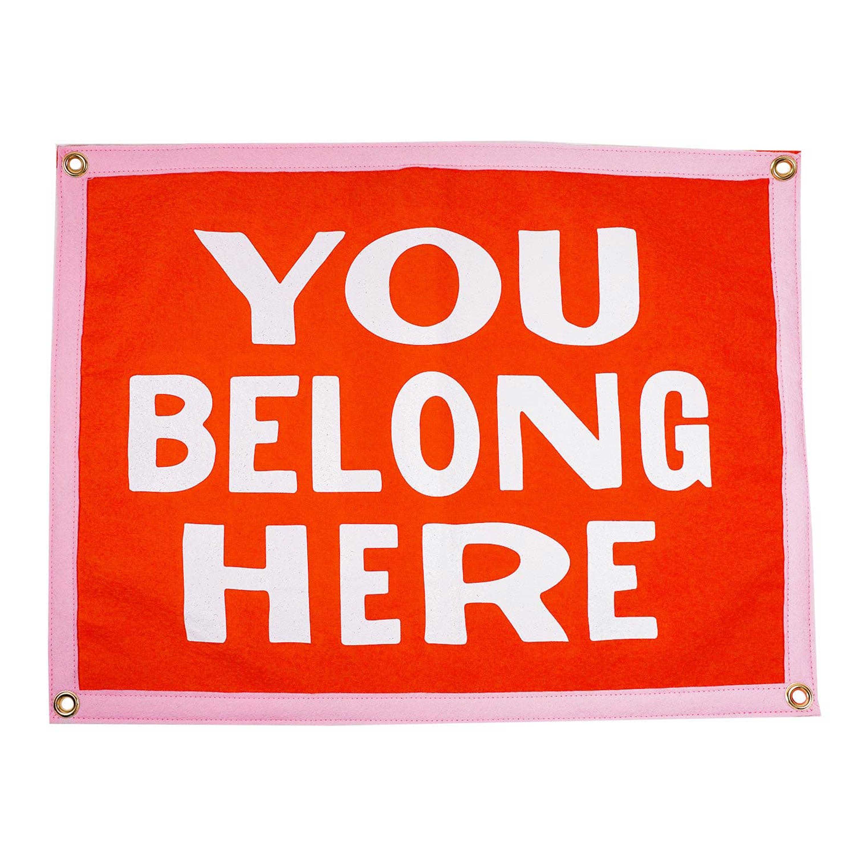 Orange felt banner with light pink boarder. White letters "YOU BELONG HERE" in middle