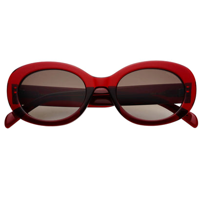 Oval sunglasses with a translucent red frame and dark tinted lenses, photographed from the front on a clean white background.