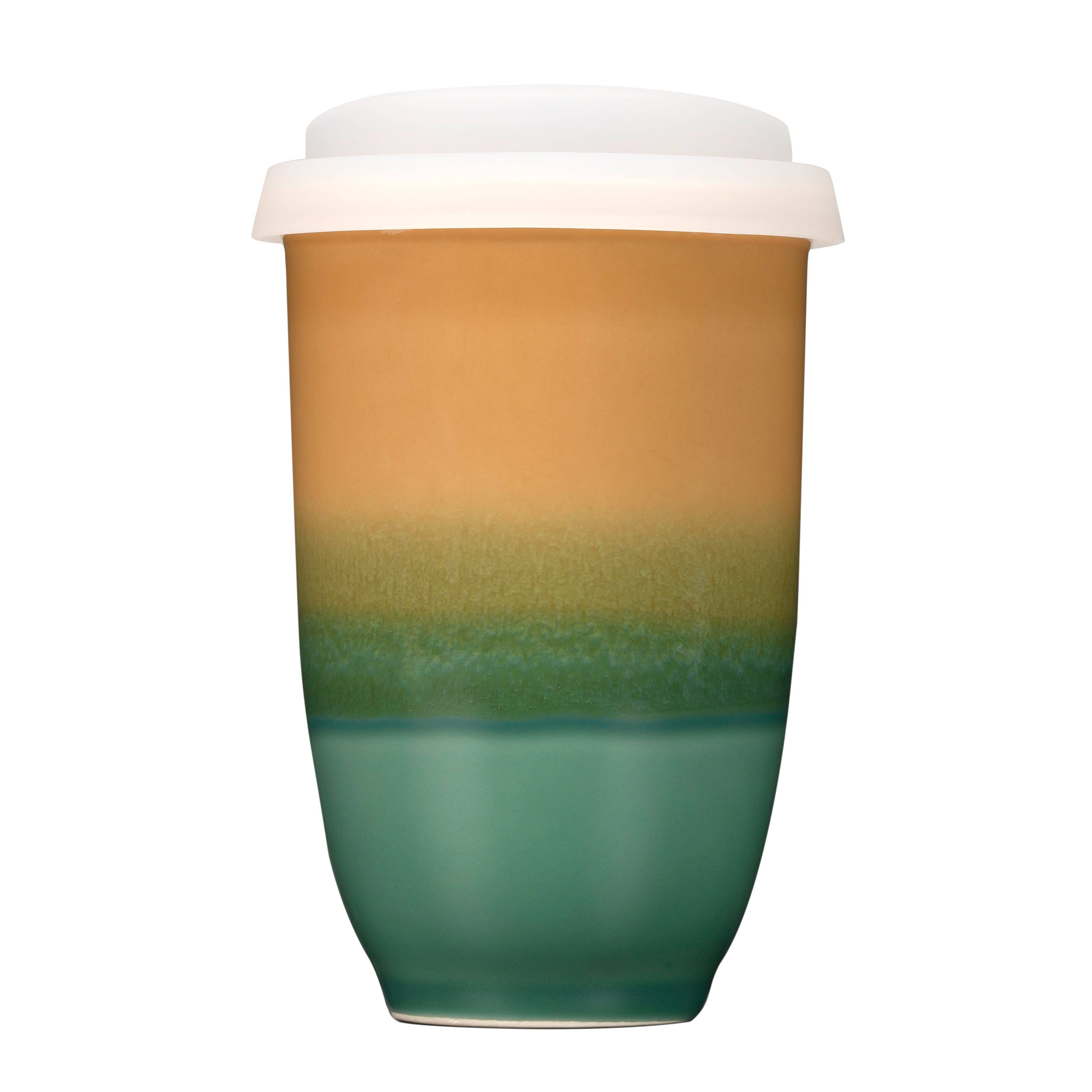 Gradient-colored ceramic tumbler with a white lid on a white background