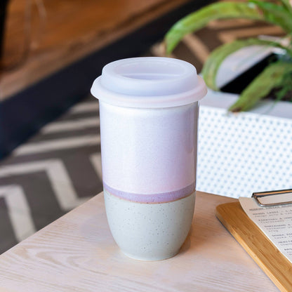 White ceramic tumbler with a purple accent on a wooden table.