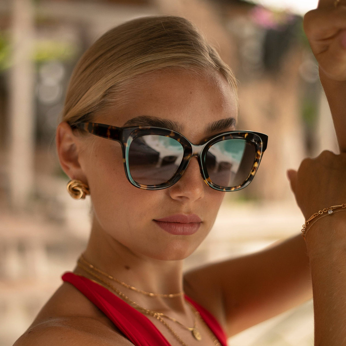 Woman wearing sunglasses with a blurred outdoor background