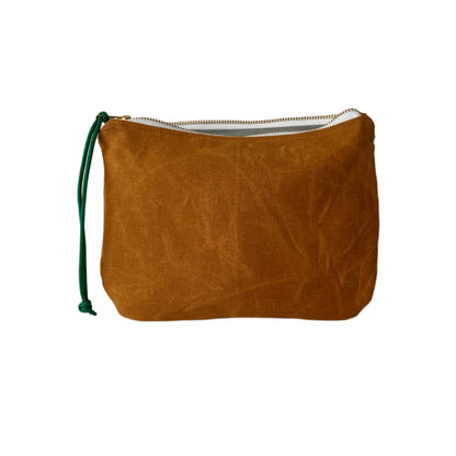Waxed canvas clutch in whiskey brown with zipper closure, compact and durable design for essentials or evening use.