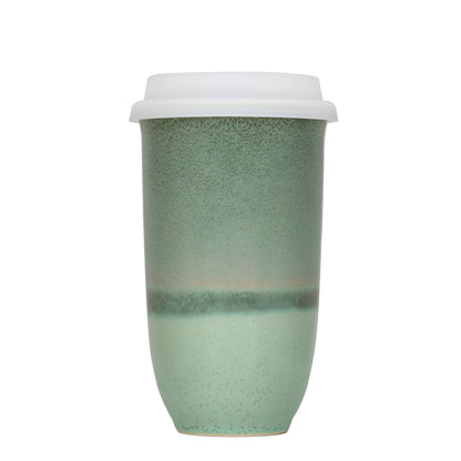 Green ceramic cup with a white lid on a white background