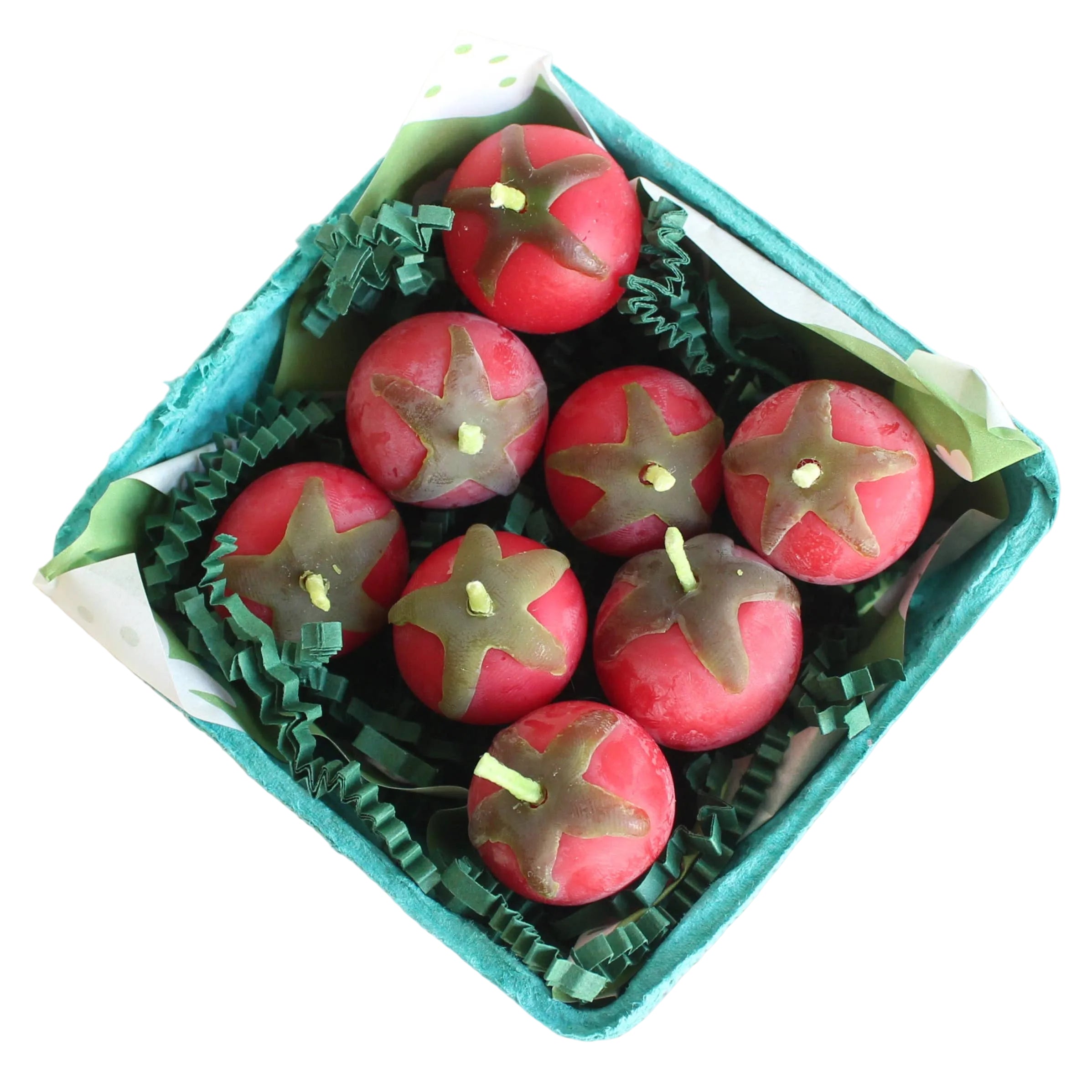 Candle shaped like tomatoes in a box on a white background