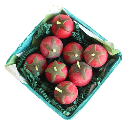 Candle shaped like tomatoes in a box on a white background