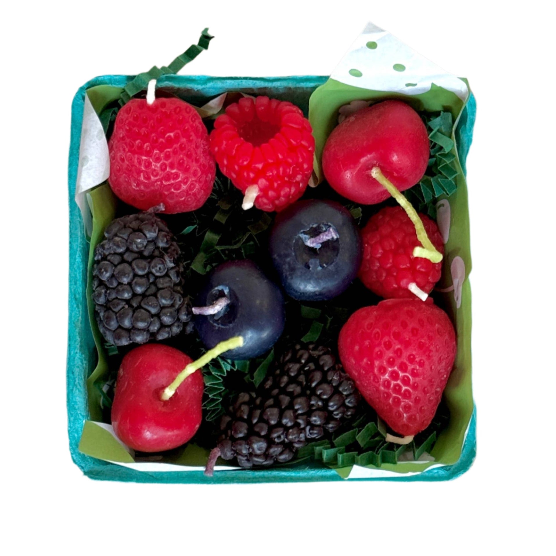 Handmade mixed berries-shaped beeswax candles sit in a paper berry basket with leafy filler. Perfect for birthdays or table decor.