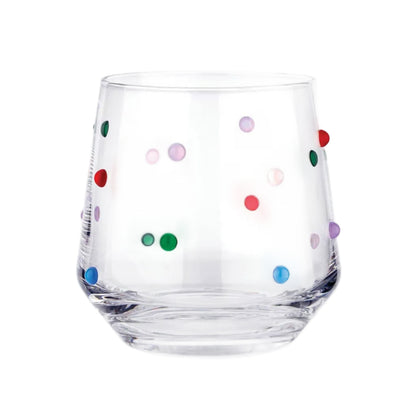Clear glass tumbler with colorful polka dots on a white background