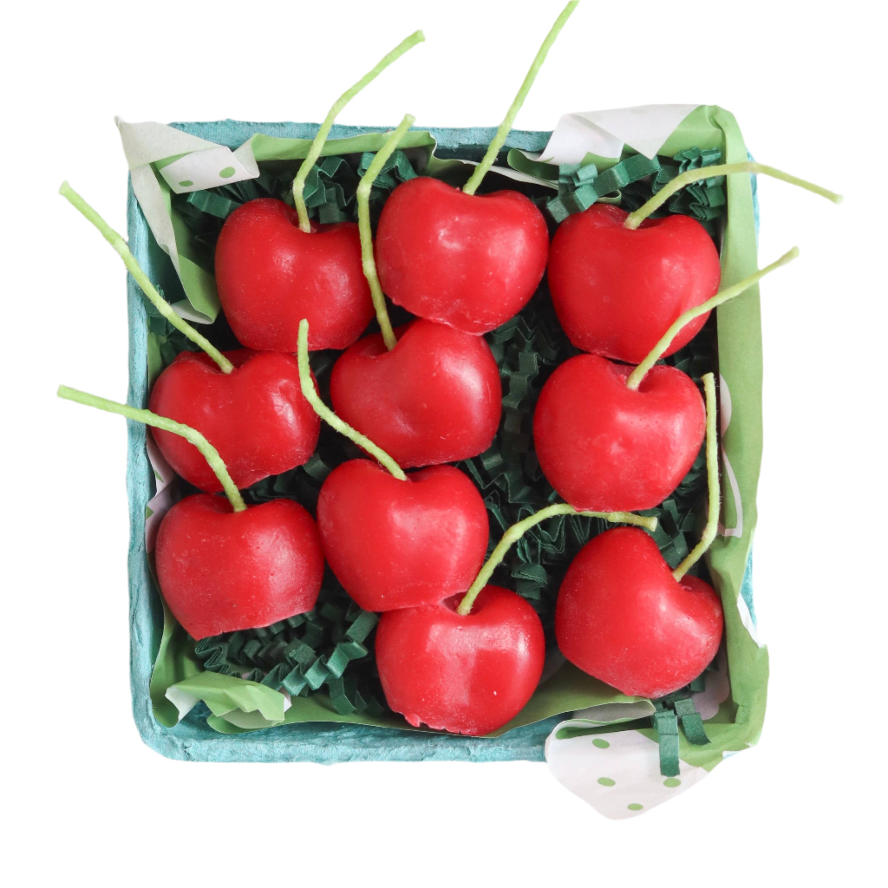 Handmade cherry-shaped beeswax candles sit in a paper berry basket with leafy filler. Perfect for birthdays or table decor.