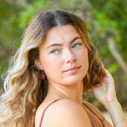 Woman with wavy hair and a brown top outdoors