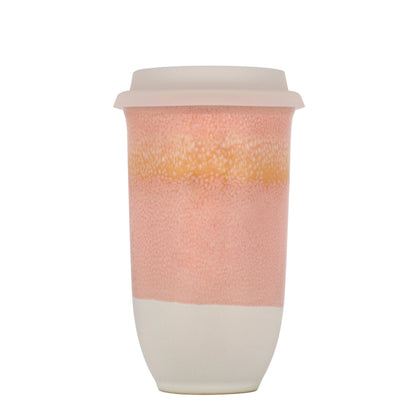 Reusable coffee cup with pink toned gradient design on a white background