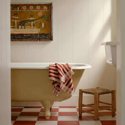 Bathroom with a freestanding bathtub, checkered floor, and decorative wall art.