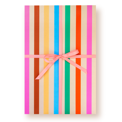Gift box with colorful striped pattern wrapping paper and pink ribbon on a white background