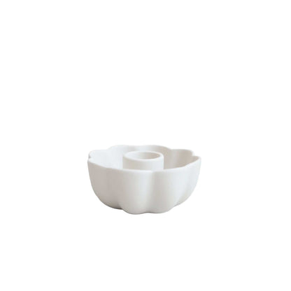 Matte white ceramic taper candle holder with scalloped edge and petal silhouette, elegant accent for tables or mantels.