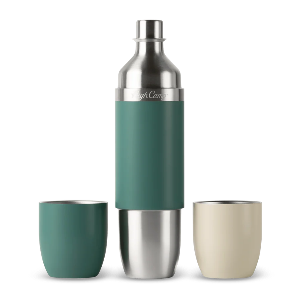 A stainless steel cocktail shaker bottle with a teal green grip sleeve, flanked by two matching tumblers on a white background. One tumbler is teal green and the other is cream beige.