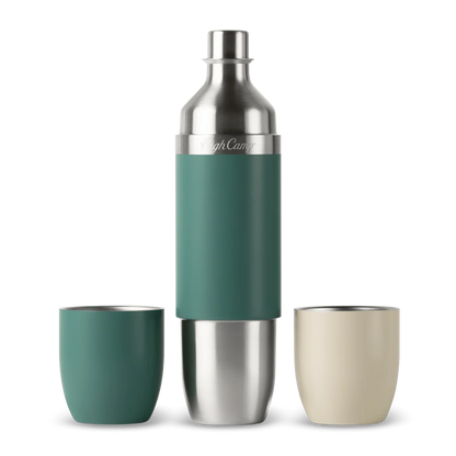 A stainless steel cocktail shaker bottle with a teal green grip sleeve, flanked by two matching tumblers on a white background. One tumbler is teal green and the other is cream beige.